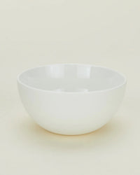 A set of four Simple Porcelain Large Bowls by Hawkins New York is displayed on a light neutral surface with a minimal, uncluttered background.