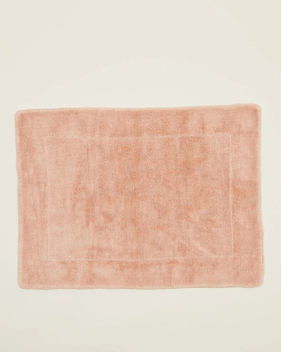 The Hawkins New York Simple Terry Bath Mat in Blush is rectangular with a plush texture and subtle border, shown on a plain off-white background.