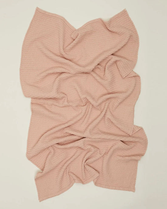 The Simple Waffle Bath Sheet in Blush by Hawkins New York, with its textured waffle weave, is spread out on a light background. The soft, cozy fabric evokes the quality of premium Portuguese-made waffle towels.