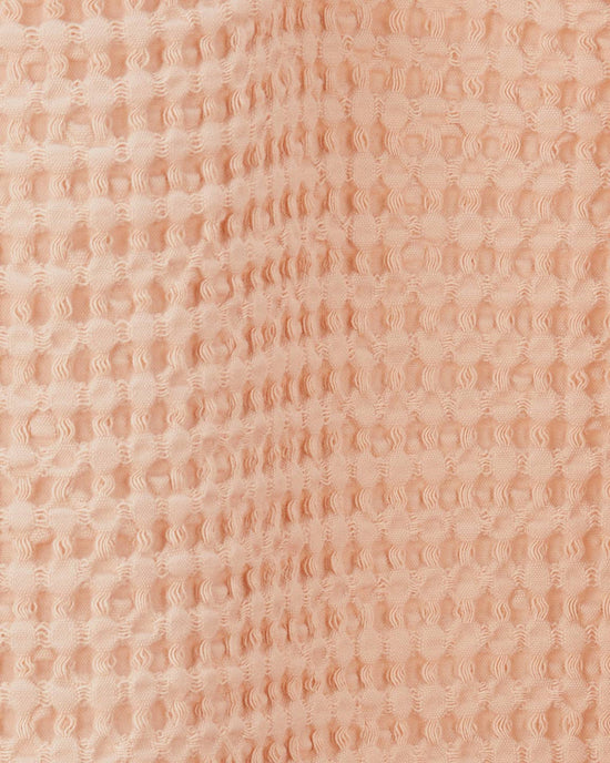 Close-up of the Simple Waffle Shower Curtain in Blush by Hawkins New York, featuring a raised, waffle-textured cotton design.