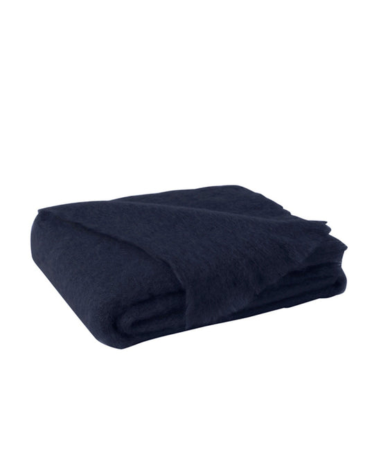 The Lands Downunder Brushed Mohair Throw in Navy, expertly woven in New Zealand, is neatly folded and displayed on a white background.