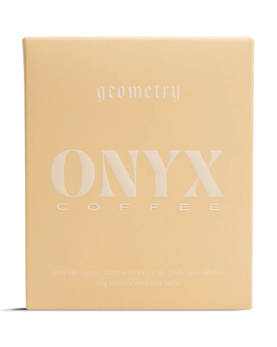 A beige 10oz bag of Onyx Coffee Lab Geometry features minimalist white text, labeled as light roast whole bean coffee for espresso or filter brewing.
