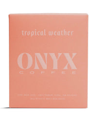 A pink box labeled Tropical Weather Coffee | 10oz by Onyx Coffee Lab features a light roast, fruit-forward, floral, and botanical whole bean Ethiopian coffee.