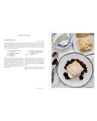 A plate with a drop biscuit topped with whipped cream and berry compote sits beside more biscuits and a bowl of whipped cream—perfect baking inspiration from Delectable by Random House, with the recipe printed on the left page.