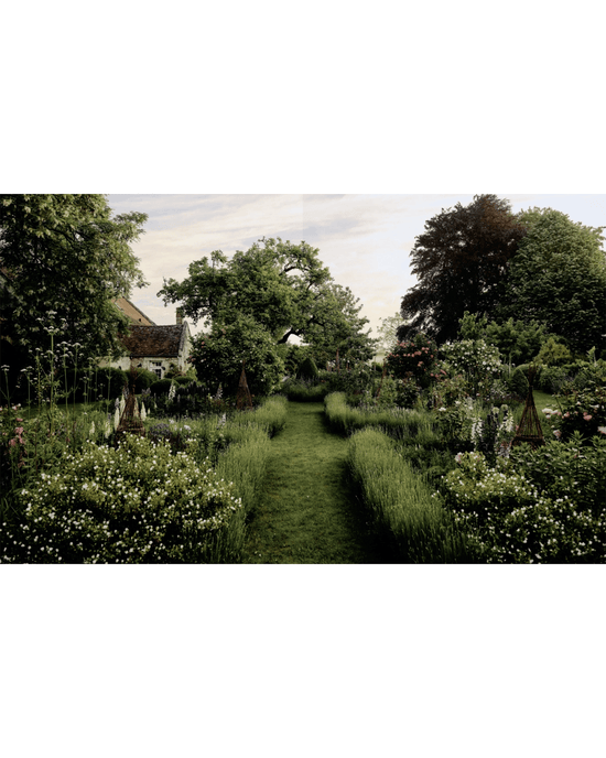 A lush garden scene from Flower Couture by Random House: neatly mowed grass paths, abundant flowering plants ideal for arranging, and trees frame a French country house partially visible on the left.