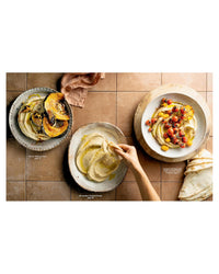 Three plates of food on a tiled floor with a hand reaching for one of the plates.