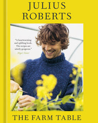 A man in a blue sweater prepares vegetables among yellow flowers, embodying farm-to-table living on the cover of The Farm Table from Random House.
