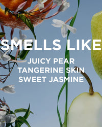 Close-up of jasmine flowers, sliced pear, and tangerine peel on blue with white text: “Smells like juicy pear, tangerine skin, sweet jasmine.” Inspired by Rosie Jane’s Perfume Oil in Leila Lou for a fresh floral scent.