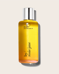 A clear bottle of yellow Missy Everyday Body Oil by Rosie Jane, featuring a shiny silver cap, is displayed against a light beige background.