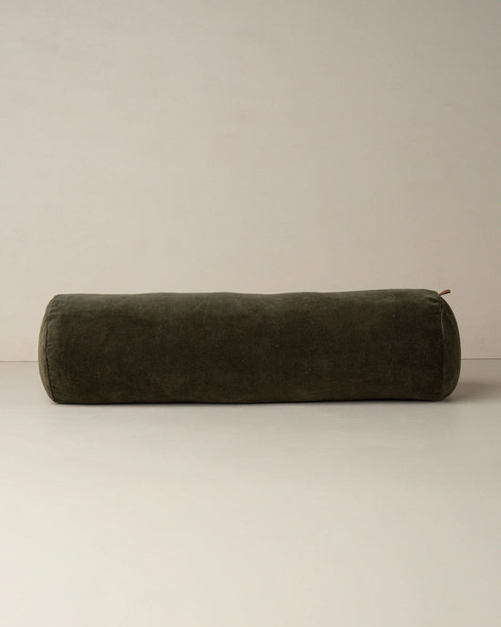 The Saarde Velvet Structured Bolster in Dark Olive is displayed on a plain light surface with a neutral backdrop.