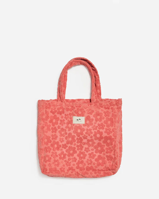 The Ginny Terry Tote Bag in Guava by Slowtide features a textured floral pattern, two handles, and a front label. Made from sustainably sourced cotton, its shown against a plain white background.