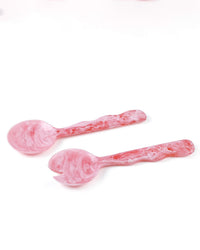The Casa Amarosa Resin Salad Server Set in Pink, featuring a spoon and wide-pronged fork with textured handles, is displayed side by side on a white background.