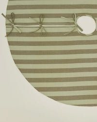 The Hawkins New York Essential Striped Tree Skirt in Olive/Sage features soft cotton, three fabric ties, and a circular opening for easy placement, shown on a white background.