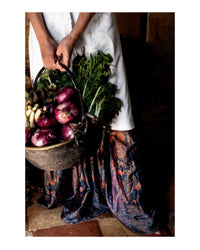 A person holds a basket of purple onions, radishes, and leafy greens—classic ingredients from authentic Italian recipes—featured in the "Old World Italian" cookbook by Random House. The image spotlights the fresh produce and their lower half.