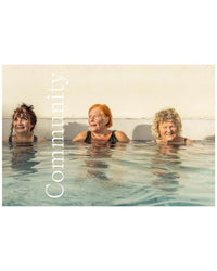Three older women smile while standing together in a natural hot springs pool. "Community" is written vertically on the left. Product: Hot Springs by Random House.