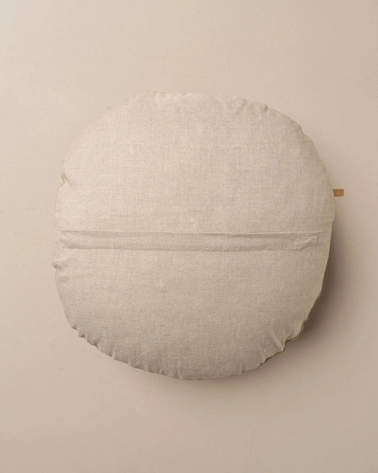 The Saarde Linen/Velvet Round Pillow with Feather Insert in Clay features a light beige tone, subtle horizontal center seam, and soft texture, shown against a plain neutral background.