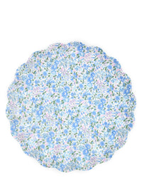 A round scalloped placemat with a blue, purple, and green floral pattern on white pairs perfectly with Meri Meri X Liberty Mixed Set Reuseable Large Plates for a coordinated and charming table setting.