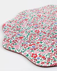 The Meri Meri x Liberty Winter Placemats S/4 feature a scalloped edge and vibrant red, pink, and green florals on white—perfect for festive Christmas tables.