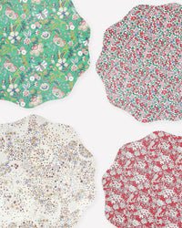 The Meri Meri x Liberty Winter Placemats S/4 by Meri Meri feature four scalloped-edge designs, each with a unique Liberty floral print in green, red, and white colorways.