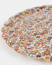A close-up of the Meri Meri x Liberty June Blossom Large Tray, featuring a scalloped edge and an intricate floral pattern in red, orange, yellow, blue, and green on a white background.