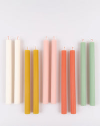 The Meri Meri x Liberty June Blossom Candle Gift Box by Meri Meri features eight ridged candles in pairs (white, mustard yellow, light pink, coral, light green), displayed vertically against a plain white background.