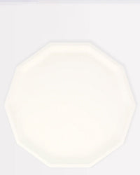A cream, decagon-shaped Meri Meri Compostable Dinner Plate—elegant and eco-friendly—takes center stage on a light background.