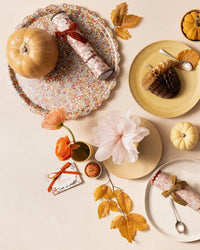 A festive autumn table setting with decorative pumpkins, floral plates, gold cutlery, autumn leaves, and a Meri Meri x Liberty June Blossom Large Tray by Meri Meri on a light beige surface.