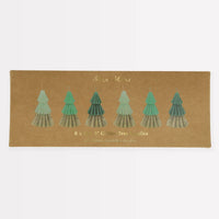 Six Meri Meri Green Mini Tree Candles with a tiered design and gold glitter accents are arranged in a brown box labeled “6 x 3.5 Glitter Tree Candles.”.