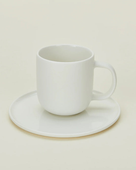 The Hawkins New York Simple Porcelain Espresso Cups & Saucers - Set of 2 features elegant white cups on matching saucers, pictured against a soft, neutral background.