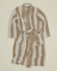 The Simple Striped Terry Bathrobe in Ivory/Flax by Hawkins New York, crafted from 100% cotton with long sleeves, two front pockets, and a matching belt, is laid flat on a plain light background.