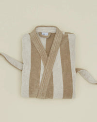 The Hawkins New York Simple Striped Terry Bathrobe in Ivory/Flax, featuring wide beige and off-white stripes, is neatly folded on a plain surface with its belt placed on each side.