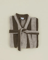 A folded Hawkins New York Simple Striped Terry Bathrobe in Light Grey/Dark Grey, featuring wide vertical stripes and a matching waist belt, displayed on a light beige background.