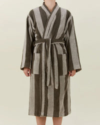 A person models the Simple Striped Terry Bathrobe in Light Grey/Dark Grey by Hawkins New York, featuring a belt and two front pockets. The 100% cotton bathrobe is shown headless against a plain light background.