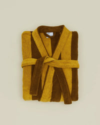The Hawkins New York Simple Striped Terry Bathrobe in Mustard/Bronze, made from 100% cotton, features vertical mustard yellow and bronze stripes with a tie belt and is displayed folded on a plain light background.