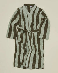 The Simple Striped Terry Bathrobe in Olive/Sage by Hawkins New York, made from 100% cotton with long sleeves and a belt, features wavy olive green and light gray vertical stripes and is shown laid flat on a beige background.