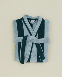 A folded Hawkins New York Simple Striped Terry Bathrobe in Sky/Peacock, featuring wide vertical dark green and light blue stripes and a matching belt, displayed on a plain light beige background.