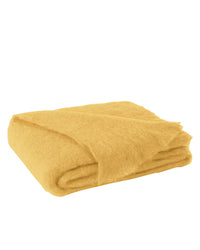 The Brushed Mohair Throw in Ochre by Lands Downunder, featuring a soft and fuzzy texture, is elegantly folded on a white background—an ideal luxury accent blanket woven in New Zealand.