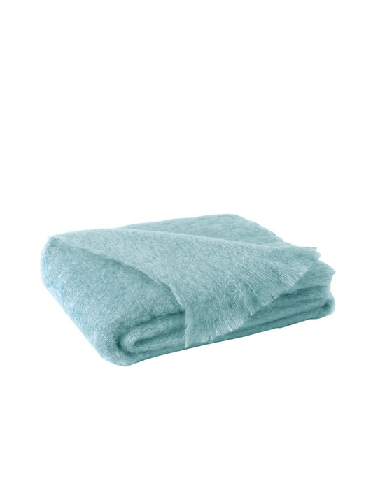 The Lands Downunder Brushed Mohair Throw in Sea Spray is a folded, light blue, fluffy blanket with a soft, fuzzy texture and fringed edges, shown against a plain white background.