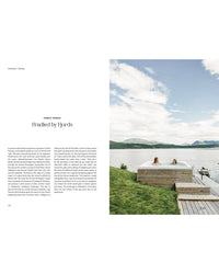 Two people relax in a spa pool beside a lake, embracing an outdoor chic vibe amid grassy land and mountains under partly cloudy Norwegian skies. The left side features text about the scene. Product: Outdoor Chic by Cozy Publishing.